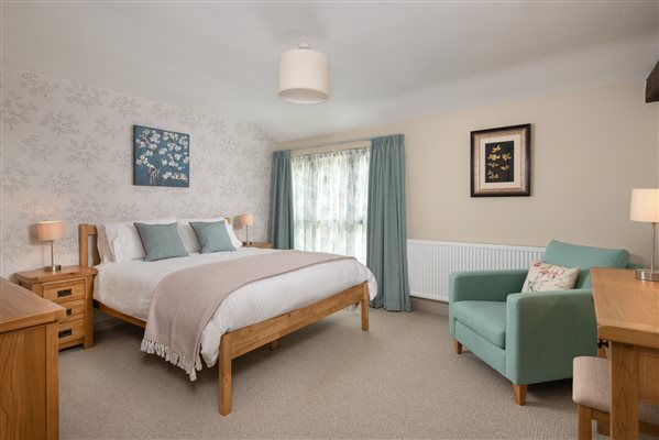 holiday cottage master bedroom with view kingsized bed and armchair